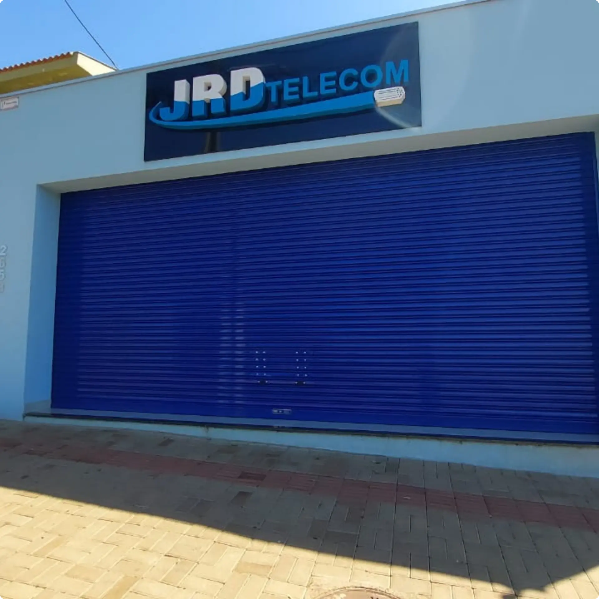 Porta automática instalada na fachada — JRD Telecom